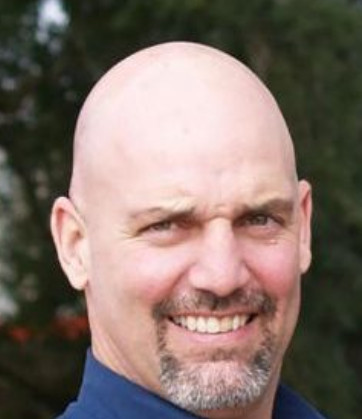 a bald man with a blue shirt and tie