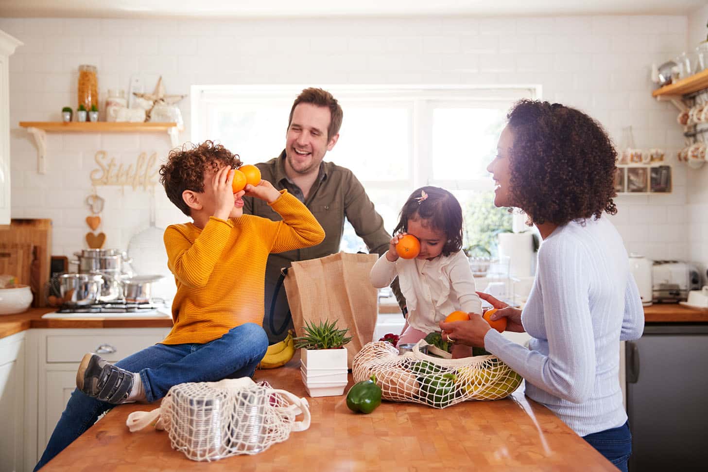 a family is gathered around the kitchen counter