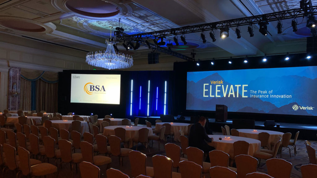 a conference room with chairs and tables in front of a large screen