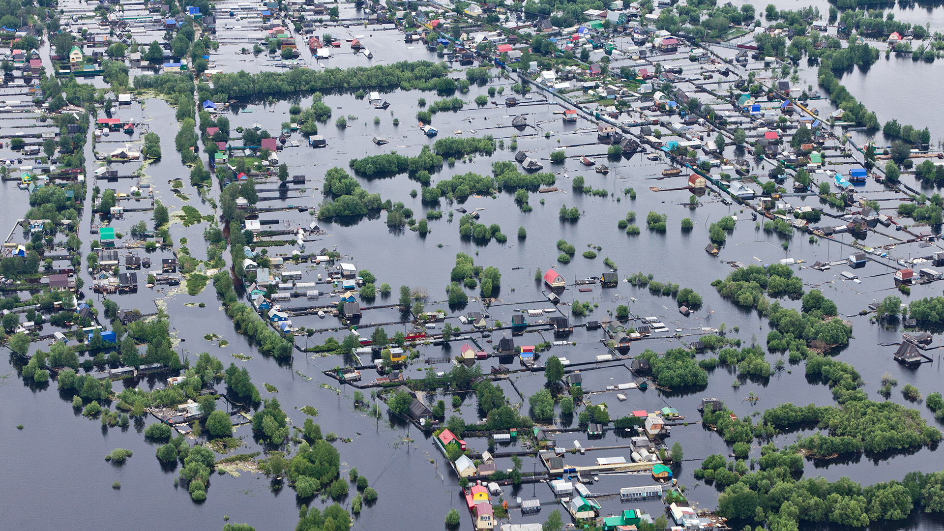 an aerial view of a flooded area with houses and boats