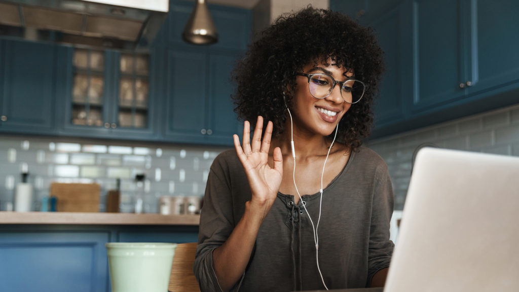 a woman wearing glasses and listening to music on her laptop