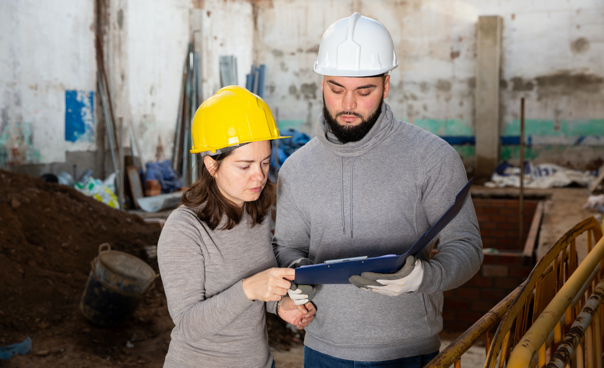 a man and woman are looking at something on a clipboard