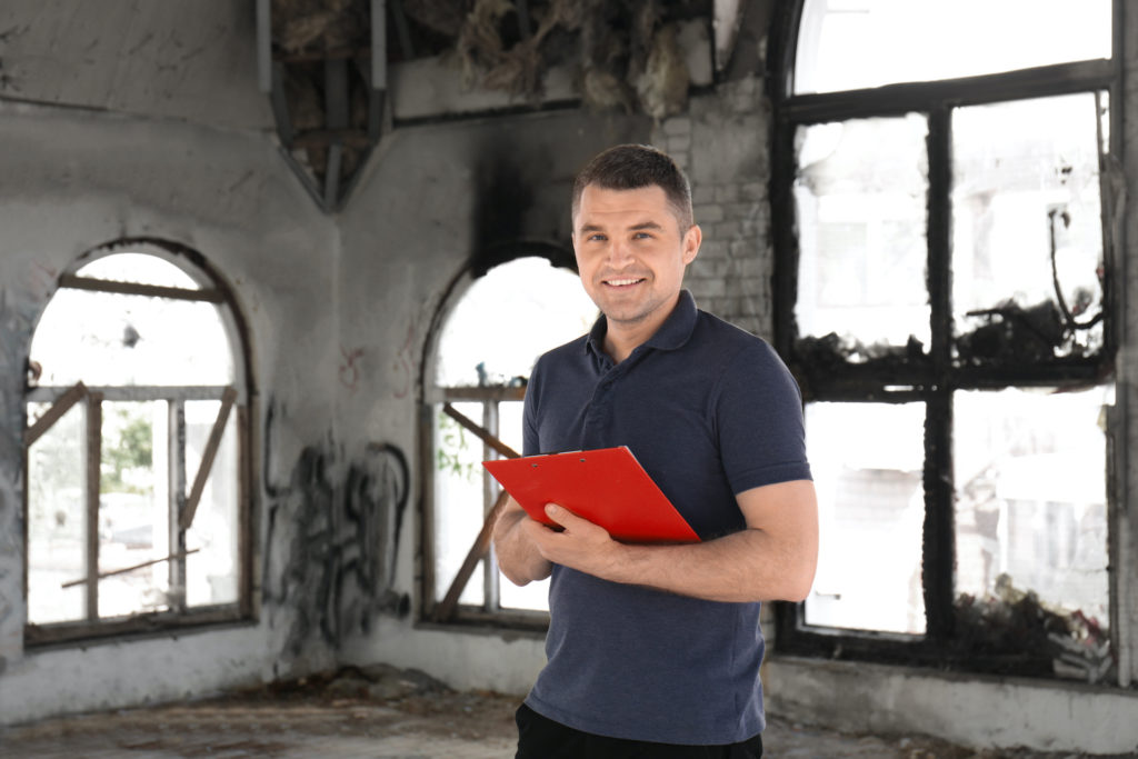 a man holding a red folder in an old building