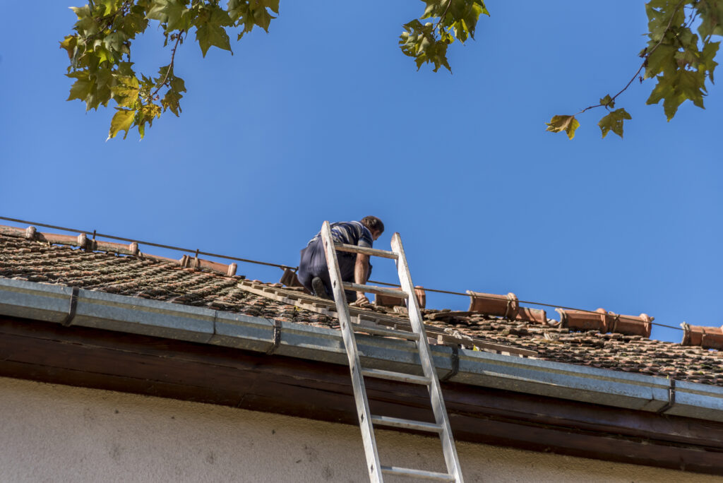 a man on a ladder working on a roof