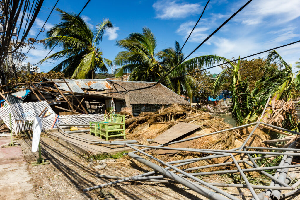 a house that has been destroyed and is surrounded by palm trees