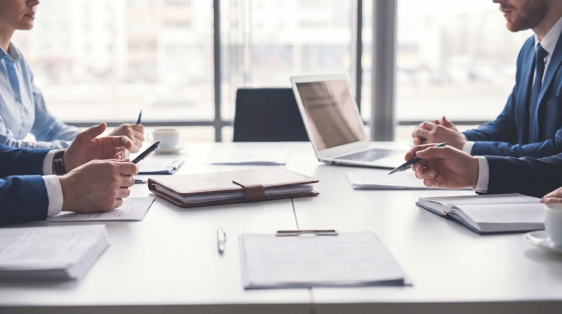 business team meeting at a table with laptop and documents
